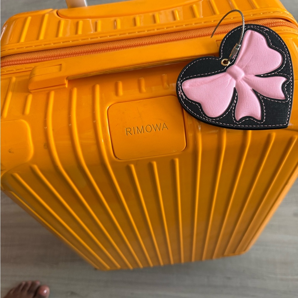 Rimowa Orange Suitcase with Pink Heart Tag